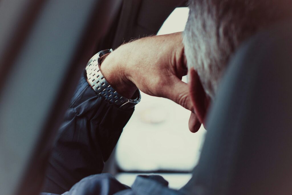 Hand eines Chauffeurs im Anzug am Lenkrad